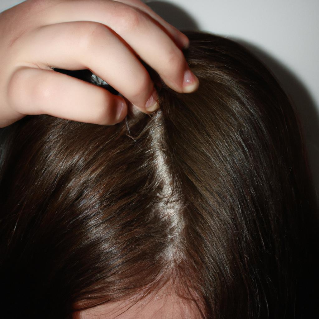Person examining their scalp closely